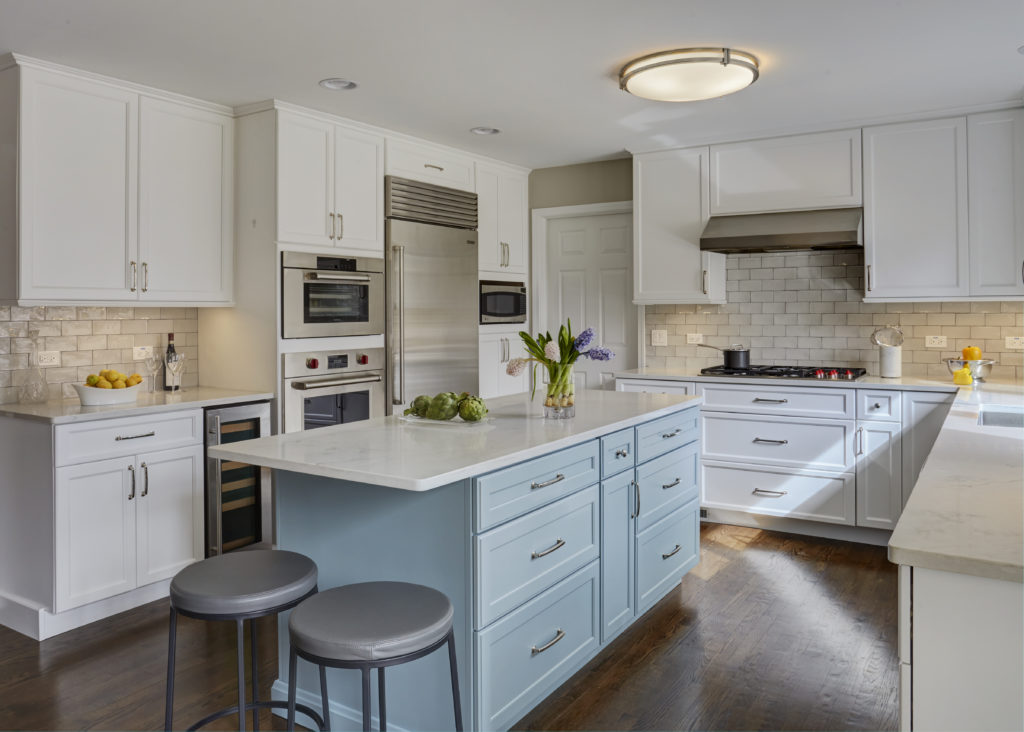 Kitchen remodel with white cabinetry and light blue island