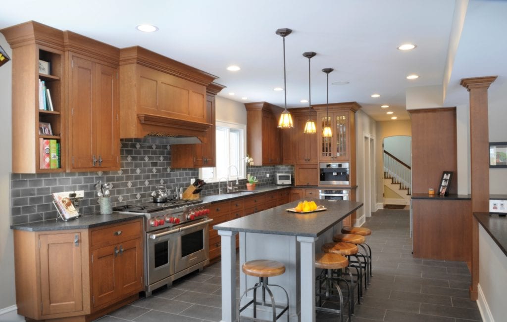 Kitchen remodel with wood cabinetry and red upholstered stools