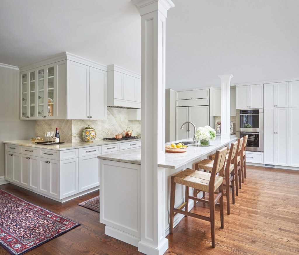 Kitchen remodel with white cabinetry and barstool seating
